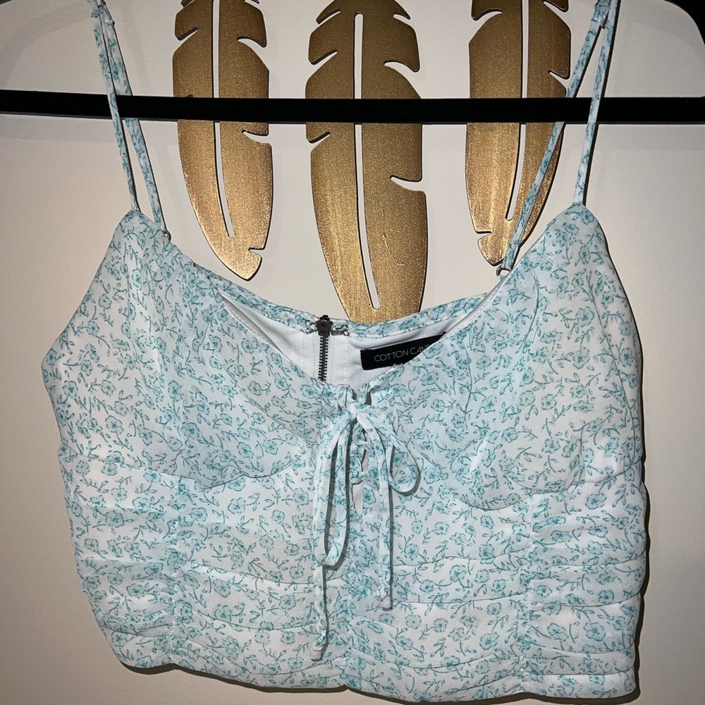 Crop blue floral tank with adjustable straps.